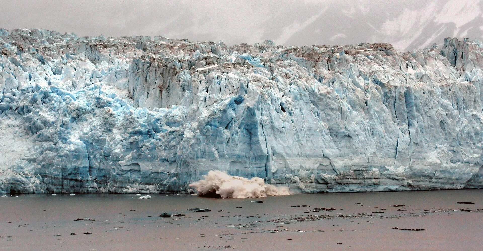 The blue-white face of Hubbard Glacier rising from the water in Alaska.