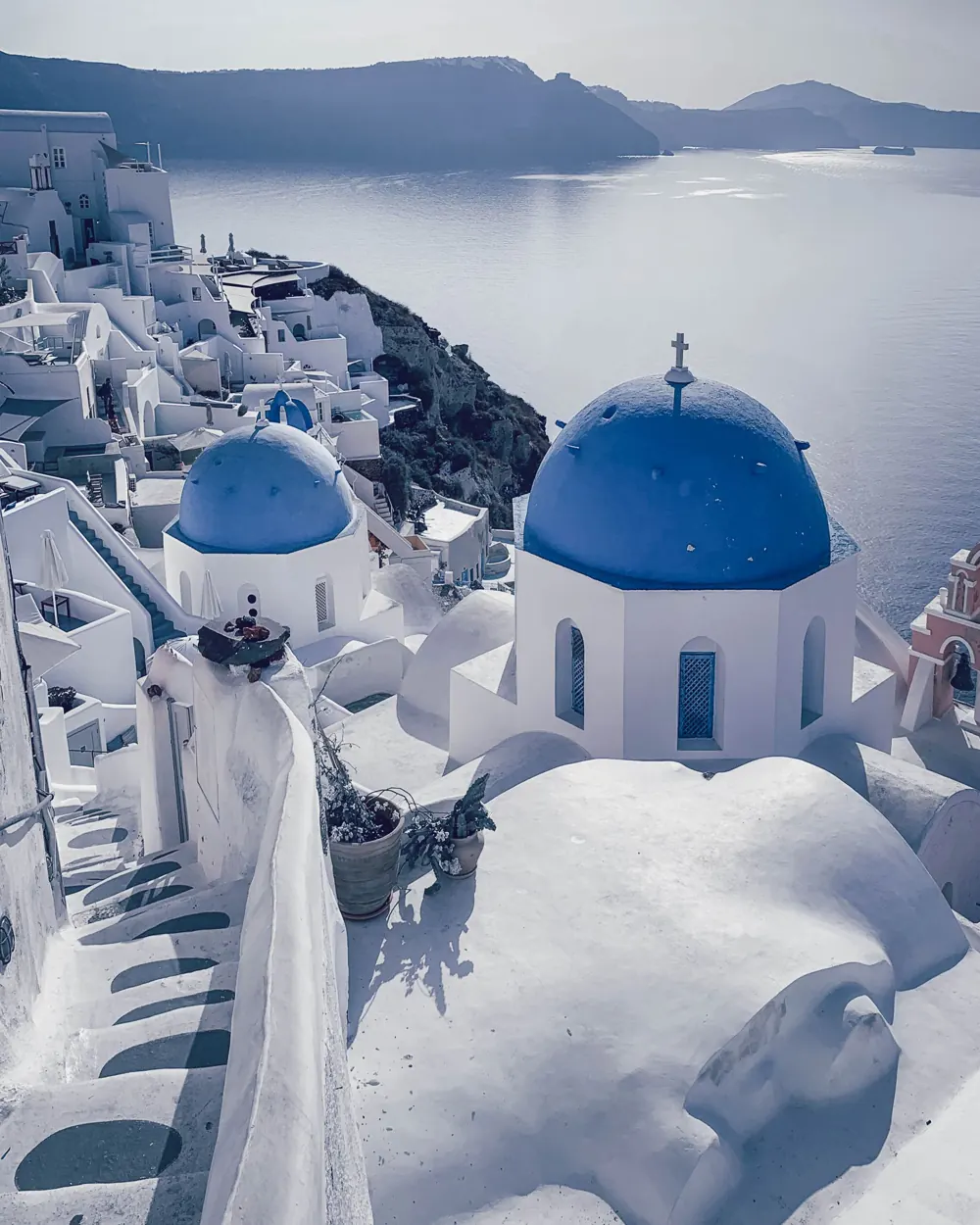 Whitewashed houses and a blue-domed church above the Aegean in Santorini.